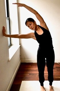 A standing side stretch beside a window